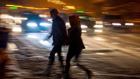 Fußgänger überqueren nachts eine Straße Fußgänger überqueren nachts eine Straße